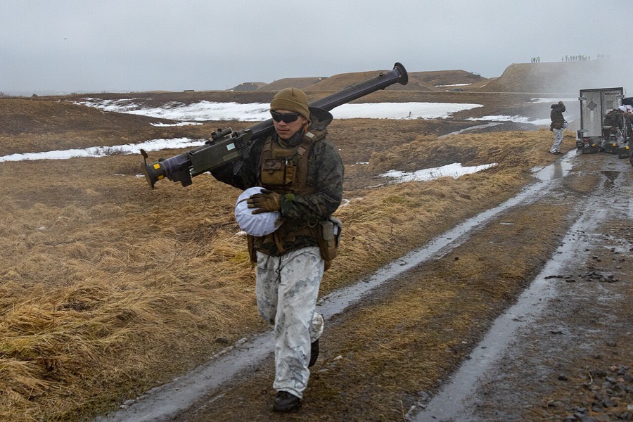 Marine carries a Stinger missile round during a live-fire exercise in Norway, 2022.